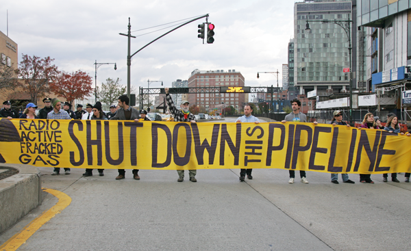 Photos by Sam Spokony Protesters unfurled a banner across West Street and blocked traffic for several minutes before they were arrested and charged with disorderly conduct.