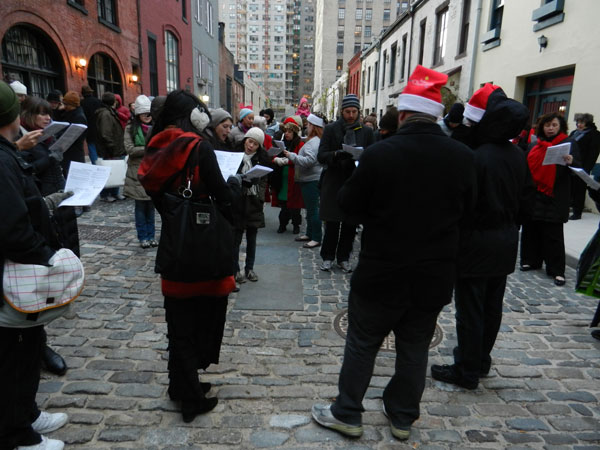 Have songbook, will travel: Carolers make a stop at Washington Mews, during 2012’s Greenwich Village Caroling Walk.  PHOTO BY DAVIS FOULGER