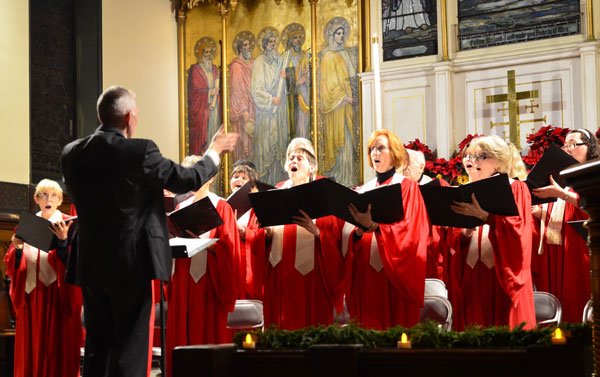 Photo by Chris Kreussling (Flatbush Gardner) From 2012: Larry Long directs the Chelsea Community Church Candlelight Carol Service choir. The annual service happens this year on Dec. 15. 