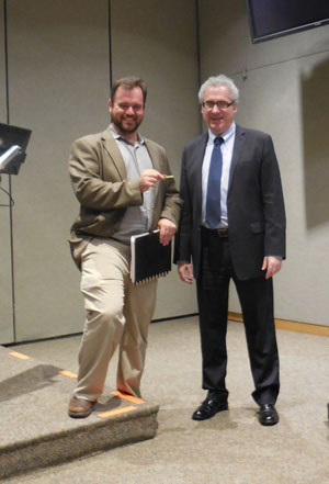 Photo by Eileen Stukane Jesse Bodine receives the key to the CB4 office from former district manager Robert Benfatto.