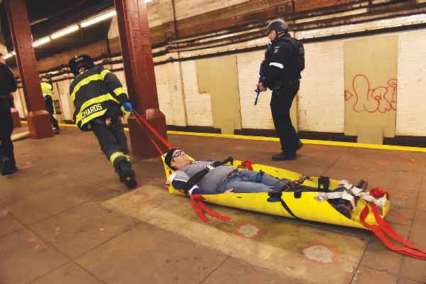 Photo courtesy of N.Y.P.D. A firefighter dragged an actor playing an injured person out of the station during the simulation.