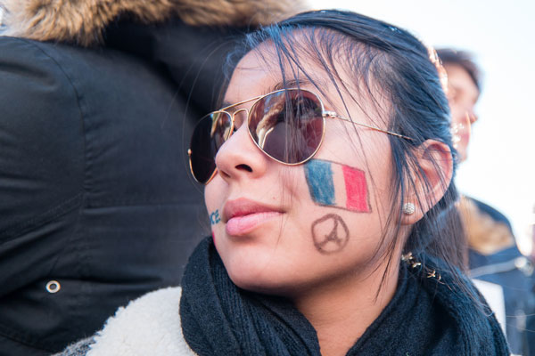 Photos by Milo Hess French patriotism was on display, and on cheeks, too, at the vigil.