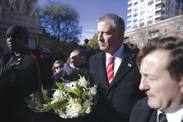 Photo by William Alatriste / NYC Council Mayor Bill de Blasio arriving at Saturday’s vigil with a bouquet of white roses and lilies, which he left on a memorial under the arch.