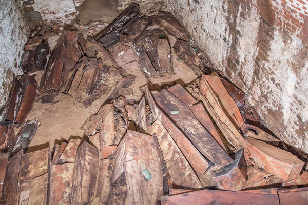 NYC Department of Design and Construction Two views — a long view and a close-up — inside one of the two burial vaults. This vault’s contents — including coffins with metal nameplates — were in better shape than the other one, which contained scattered skeletal remains previously disturbed by a 1960s Con Ed project.