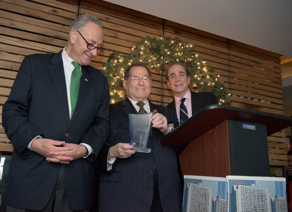 Congressman Jerrold Nadler, center, holding his award from the Gateway Plaza Tenants Association, flanked by association president Glenn Plaskin on the right and Sen. Charles Schumer on the left, at the G.P.T.A. holiday party on Dec. 6.