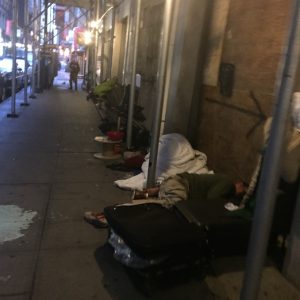 Photo courtesy of Andrea Kanter The eight-year-old sidewalk shed on John Street is home to a chronic homeless encampment, where vagrants set up furniture and cardboard shanties beneath the relative sanctuary the shed provides. 