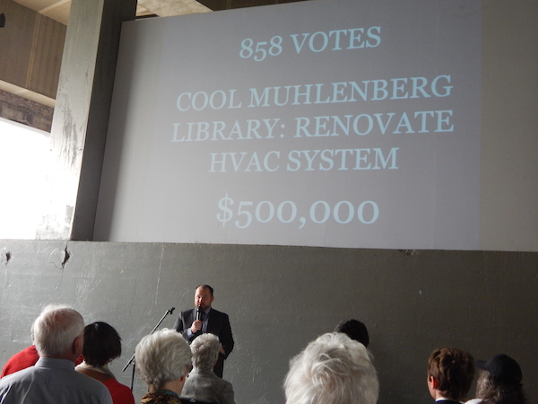 Councilmember Corey Johnson reveals the number two vote-getter, the air conditioning system at Muhlenberg Library. Photo by Sean Egan.