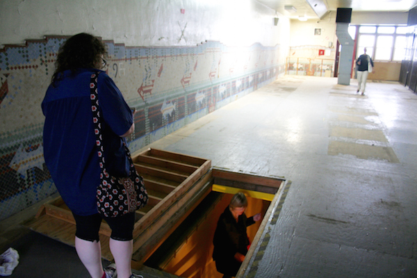 Visitors exploring the pool, which was used by sailors in the building’s days as a YMCA, but was later covered with plywood and used as a storage space by the prison. Photo by Yannic Rack.