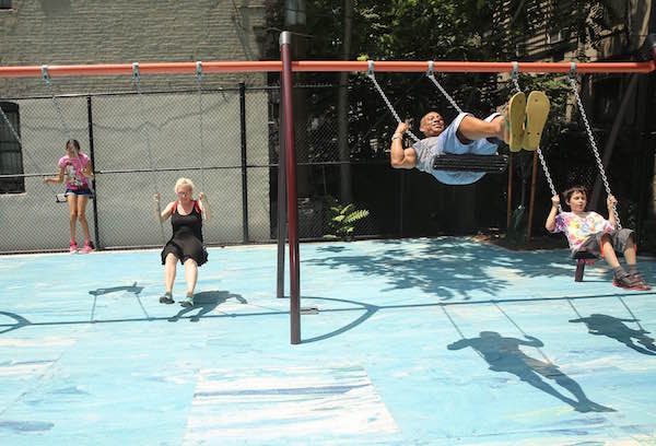 Community members enjoy the swings in newly-renovated Ramon Aponte Park. Photo by William Alatriste/NYC City Council.