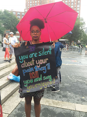 Indigo Goodson of Brooklyn carried a sign at a July 8 rally in Union Square. Photo by Lauren Vespoli.