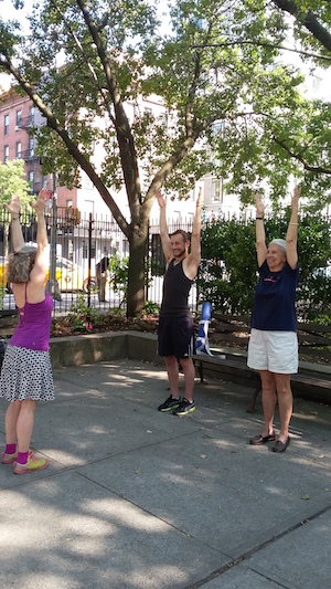 Anita Haravon leads Anna Sewell and Mike Shawe in low-impact stretching and yoga. Classes take place at 9am every Wed., in Clement Clarke Moore Park. Photo by Allen Oster.