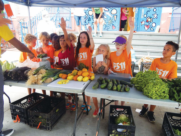 Third graders at the PS 11 Farm Market clamor to answer a customer’s question. Photo by Jane Argodale.