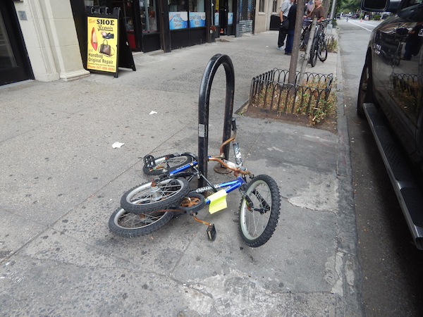 Both of these bikes on W. 21st St. (btw. Eighth & Ninth Aves.) have a lot of rust. Can you figure out why only one of them is tagged for removal? Photo by Jane Argodale.