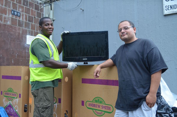 Event staffer Malcolm Jenkins, left, and LESEC Warehouse Logistics Manager Noel Gonzalez show off a television dropped off at their collection event. Photo by Alex Ellefson.