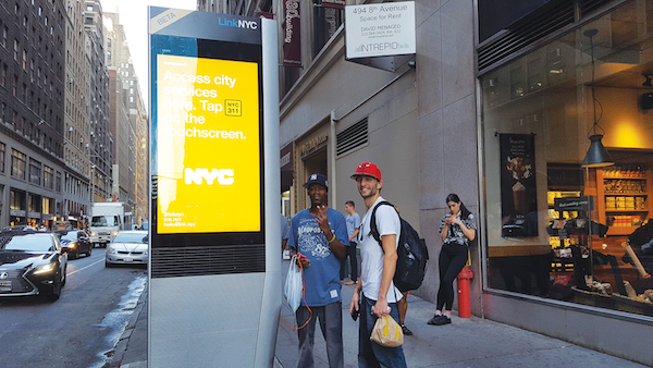 L to R: Damon Callaway and James Gambardella use a terminal at W. 35th St. & Eighth Ave. Photo by Dusica Sue Malesevic. 