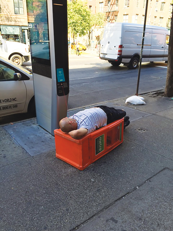 Chelsea resident Pamela Wolff took this photo of a man who spent hours at a kiosk on Eighth Ave., btw. W. 21st & W. 22nd Sts. Photo by Pamela Wolff.