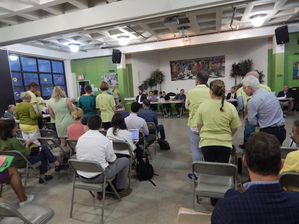 At Sept. 7’s CB4 meeting, opponents to the 334 W. 20th St. project showed off their numbers by standing strong in neon green T-shirts. Photo by Sean Egan.