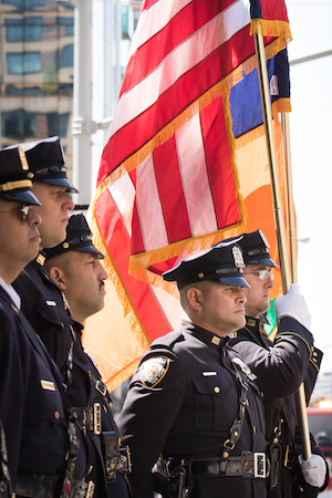 The color guard stands at attention as Father Chris Keegan reads the names of victims. Photo by Daniel Kwak.