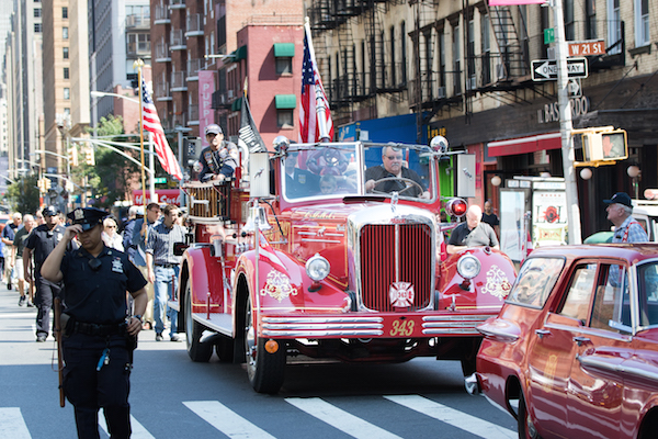 The Walk of Remembrance approaches W. 19th St., led by a vintage fire engine. Photo by Daniel Kwak.