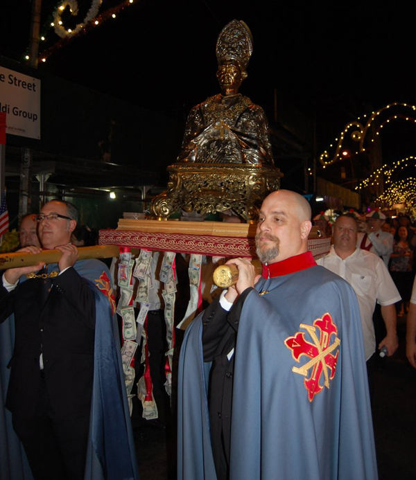 Photo by Andrew Giordano Charles Sant’Elia, left, and John Napoli, both knights of the Sacred Military Constantinian Order of St. George, hoist the icon of San Gennaro in a three-hour procession honoring the Catholic martyr on Sept. 19.