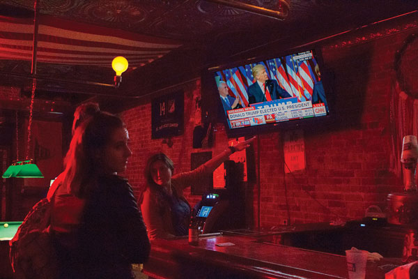 Customers at Blue Ruin, a bar near the intersection of W. 40th St. & Ninth Ave., react to Donald Trump's victory speech early in the morning on Wed., Nov. 9. Photo by Zach Williams.