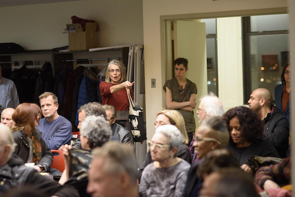 The woman in red asked, "Why didn't landlords go to jail if falsifying permits is a felony?" Photo by Jordan Rathkopf.