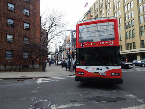 A “hop-on, hop-off” tour bus turns from 10th Ave. onto W. 26th St. to make a northbound turn onto Eighth Ave. Photo by Dennis Lynch.