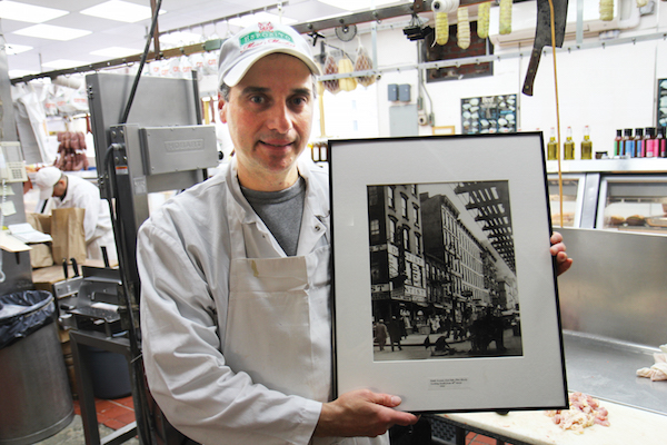 Third-generation owner Robert Esposito holds up a photo of the block from 1932, the year his grandfather opened the butcher shop. Photo by Dennis Lynch.