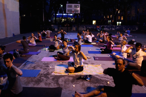 Candlelight yoga has been among the “Healthy Hell’s KitcheNights” activities programmed in Mathews-Palmer Playground by the Hell’s Kitchen Commons neighborhood coalition. Photo by Ron Haviv/VII Photo Agency.