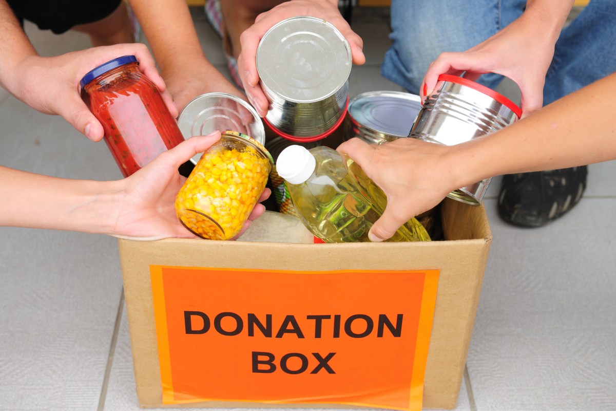 People putting food in a donation box