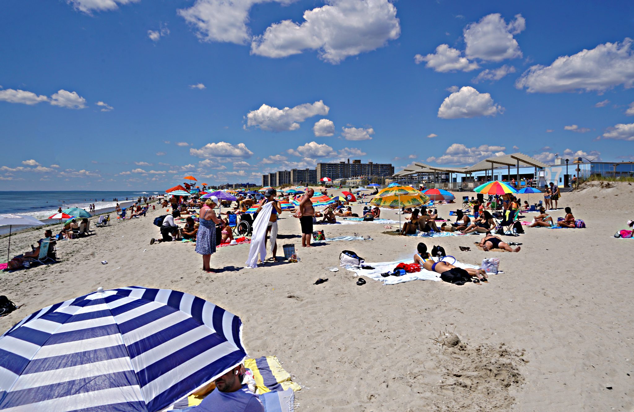 Beachgoers test the waters at Rockaway Beach as pandemic life presses