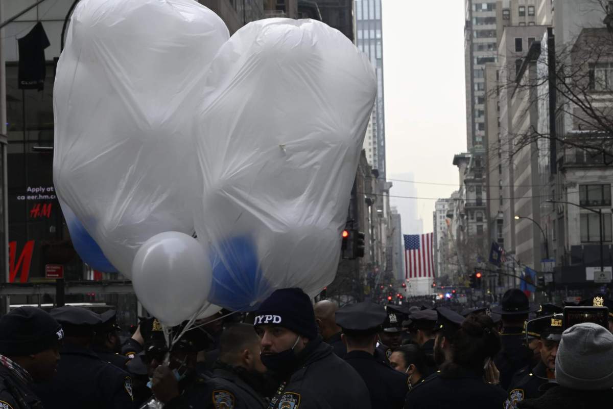 Balloons bob above an ocean of officers