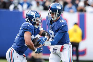 Giants quarterback Mike Glennon hands the ball off to Saquon Barkley.