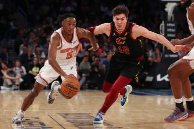 Knicks guard Immanuel Quickley dribbles the ball past Cleveland Cavaliers forward Cedi Osman.