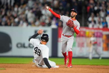 Red Sox second baseman Jonathan Arauz turns a double play with New York Yankees first baseman Anthony Rizzo sliding into second base.