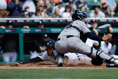 Tigers right fielder Victor Reyes dives in safe at home ahead of the tag by Yankees catcher Jose Trevino in the 3rd inning of the shutout game.