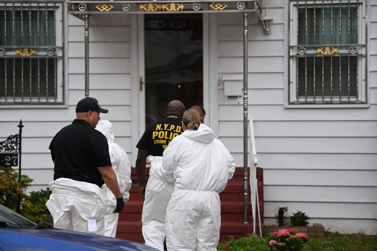 Crime scene detectives donning Tyvek suits make their way into the home