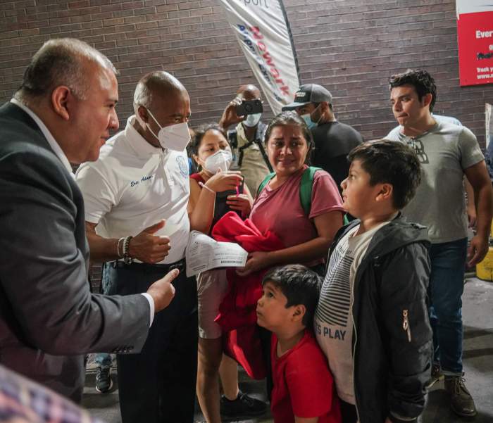 Mayor Eric Adams greets a family of migrants as they arrive from the Texas border