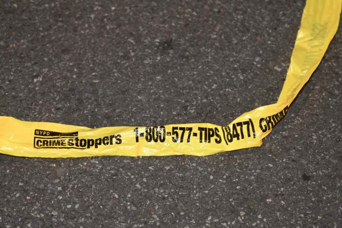 Police tape lies on the ground of a crime scene