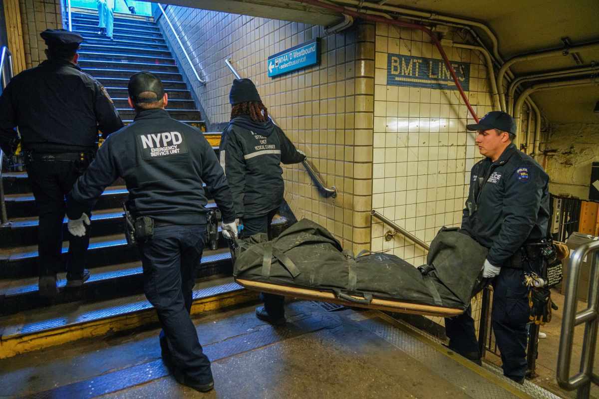 Police carry one of the two people struck and killed by an L train in Manhattan