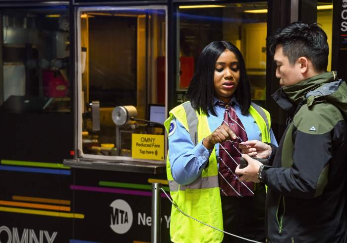 A station agent talks to a rider at Fulton Center