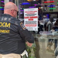 Cannabis enforcement officer posts sign on raided store in Manhattan
