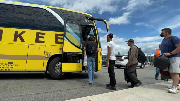 Hudson Line customers board a Yankee Line bus at Croton-Harmon station amid the railroad's partial shutdown