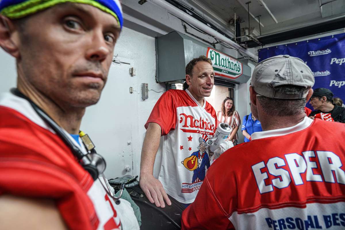 A rain-soaked Joey Chestnut and fellow competitors inside during the lightning delay in the Nathan’s Hot Dog-eating contest