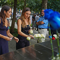 Mourners place flowers on 9/11 Memorial wall