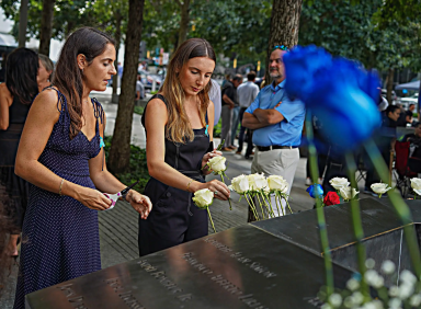 Mourners place flowers on 9/11 Memorial wall