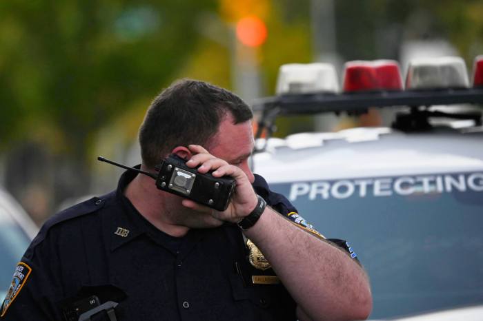 A NYPD Sergeant listens to a hand held radio