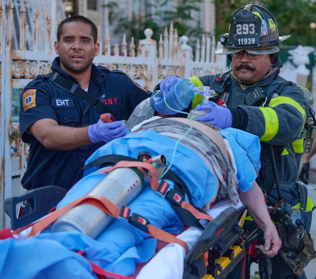 A Firefighter and Paramedic treat an injured civilian overcome by smoke inhalation during a house fire at 196 Fountain Avenue. Paramedics removed her to Jamaica Hospital in critical condition