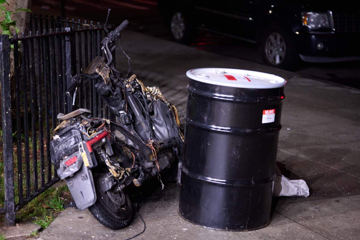 Charred e-bike and barrel with lithium ion battery after Brookklyn fire