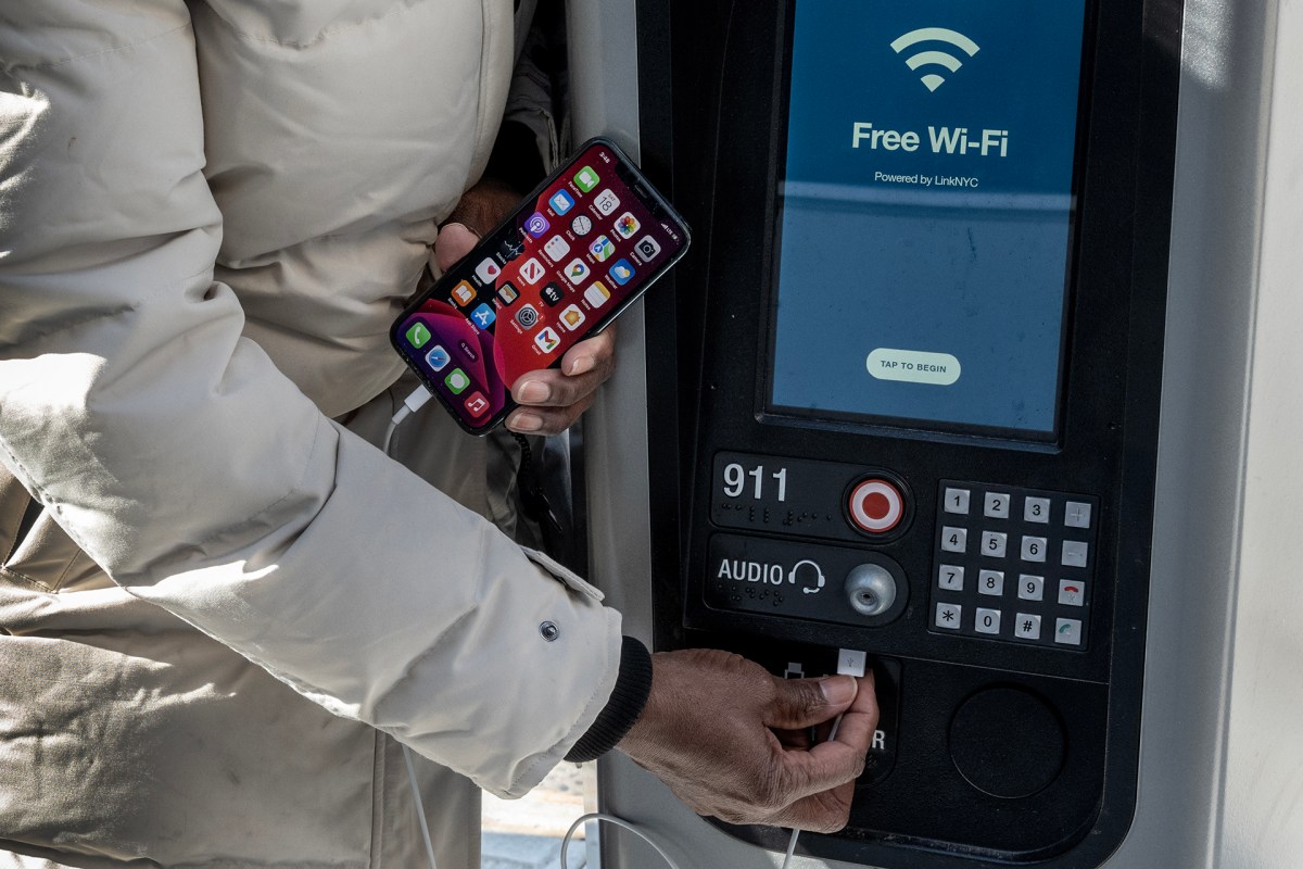 Connecting a phone at a LinkNYC tower in Queens